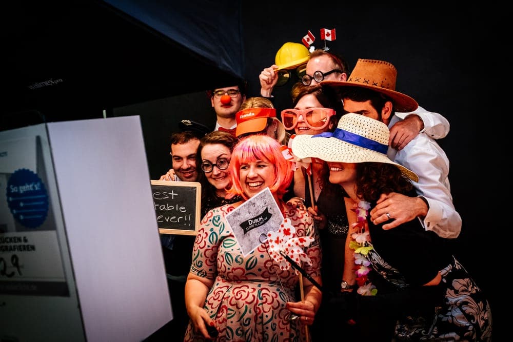Gruppe mit Requisiten an der Fotobox auf einem Geburtstag